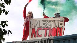 BRANDON, ENGLAND - JULY 1: BRANDON, ENGLAND -JULY 1:  Activists hold a banner saying 'Palestine Action' while letting off smoke flares during the occupation on July 1, 2025 in Brandon, United Kingdom. Activists from Palestine Action occupied the roof of Guardtech, a company they accuse of being in business with Israeli defense contractor Elbit Systems. The protest action comes as the government is attempting to proscribe the organisation by amending the Terrorism Act of 2000. If the government win the vote later this week Palestine Action will be put on the banned list of organisations. (Photo by Martin Pope/Getty Images)