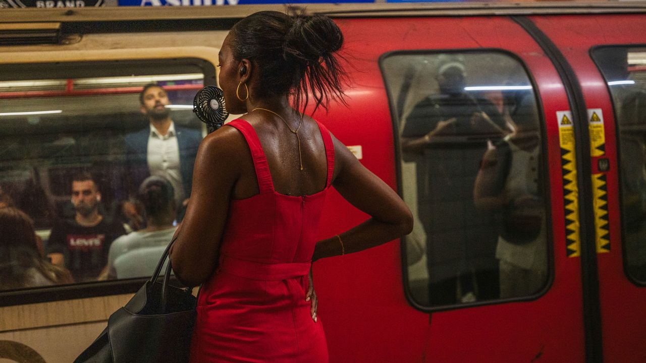 A commuter holds a portable handheld electric fan as she waits for an underground train at rush hour during a heat wave in financial district of the City of London, UK, on Tuesday, July 1, 2025. Unusually hot weather is making it almost unbearable to travel on the UK capital's underground train network. Photographer: Jose Sarmento Matos/Bloomberg via Getty Images