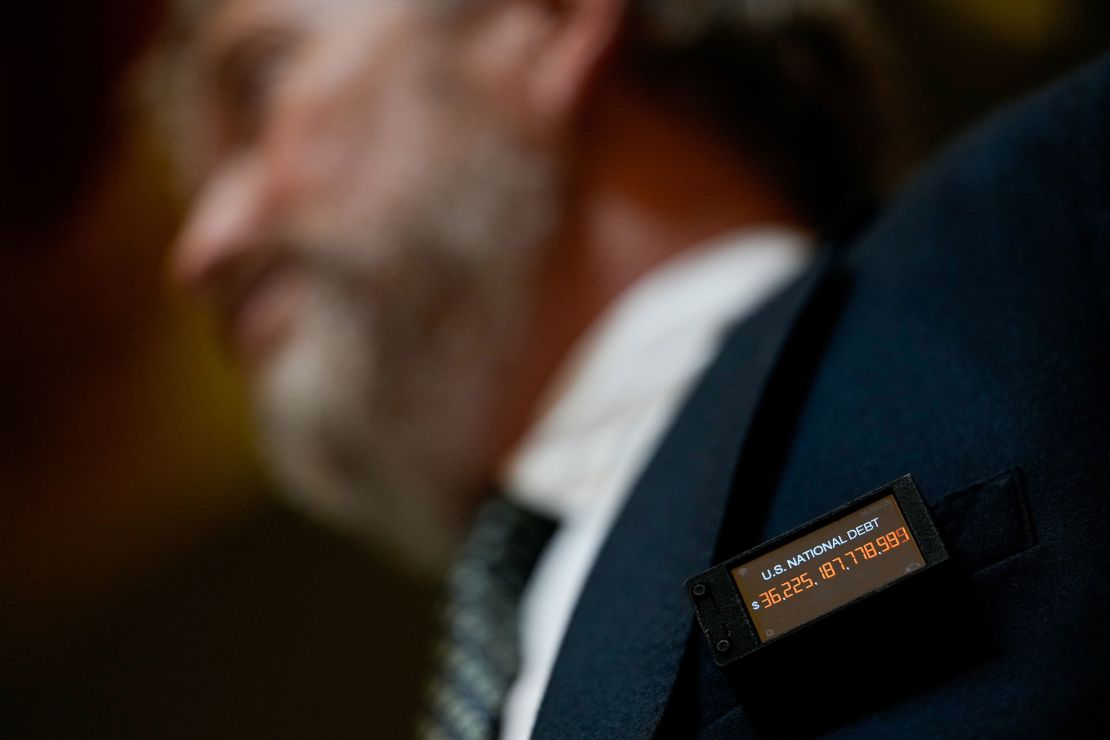 Rep. Thomas Massie wears a digital pin tracking the the US national debt on Wednesday.
