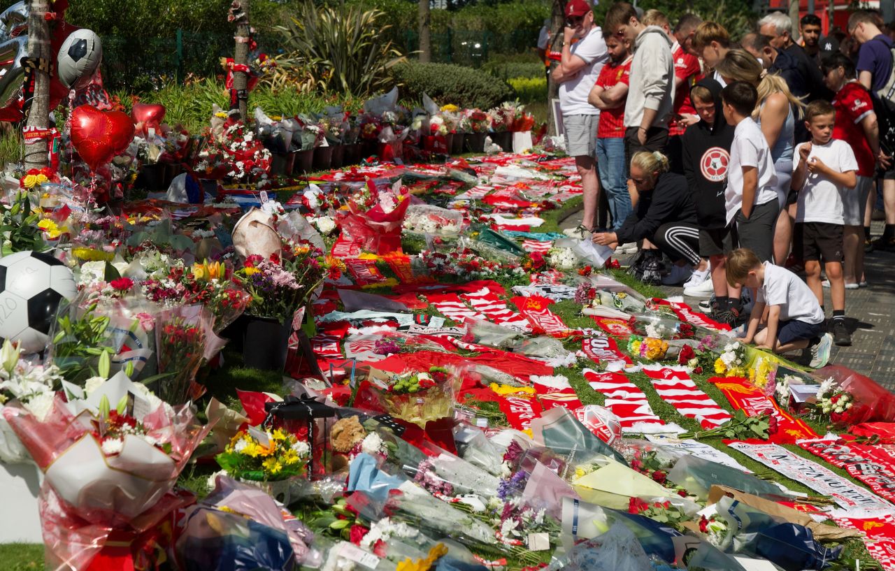 People leave flowers at a memorial near Anfield stadium in Liverpool, England on Thursday.