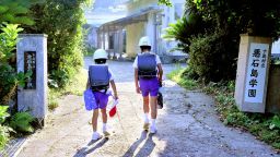 Children of Akusekijima Gakuen wearing helmets on their way to school in Akusekijima, Japan on June 30, 2025.