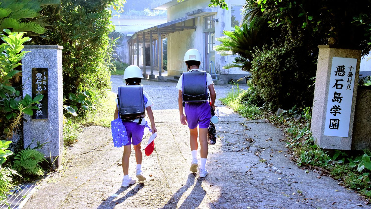 Schoolchildren on Akusekijima, in Japan's remote Tokara Islands, wearing helmets on their way to class on June 30, 2025.