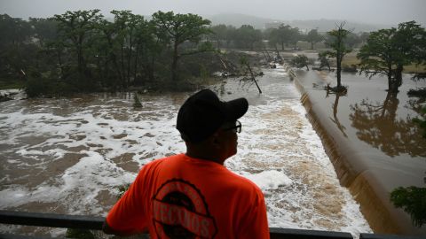 A member of the public looks out at flooding caused by a flash flood at the Guadalupe River in Kerrville, Texas, on July 5, 2025. Rescuers were desperately searching for at least 20 girls missing from a riverside summer camp, officials said on July 5, after torrential rains caused a "catastrophic" flash flood that killed at least 24 people as it swept through south-central Texas.