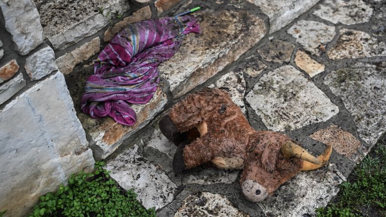 A plush toy sits on the ground outside of a cabin at Camp Mystic, the site of where at least 20 girls went missing after flash flooding in Hunt, Texas, on July 5, 2025. Rescuers were on Saturday searching for more than 20 girls missing from a riverside summer camp in the US state of Texas, after torrential rains caused devastating flooding that killed at least 27 people -- with more rain on the way. "So far, we've evacuated over 850 uninjured people, eight injured people and have recovered 27 deceased fatalities at this time. Of these 27, 18 are adults, nine are children," said Kerr Country Sheriff Larry Leitha on July 5. (Photo by RONALDO SCHEMIDT / AFP) (Photo by RONALDO SCHEMIDT/AFP via Getty Images)          