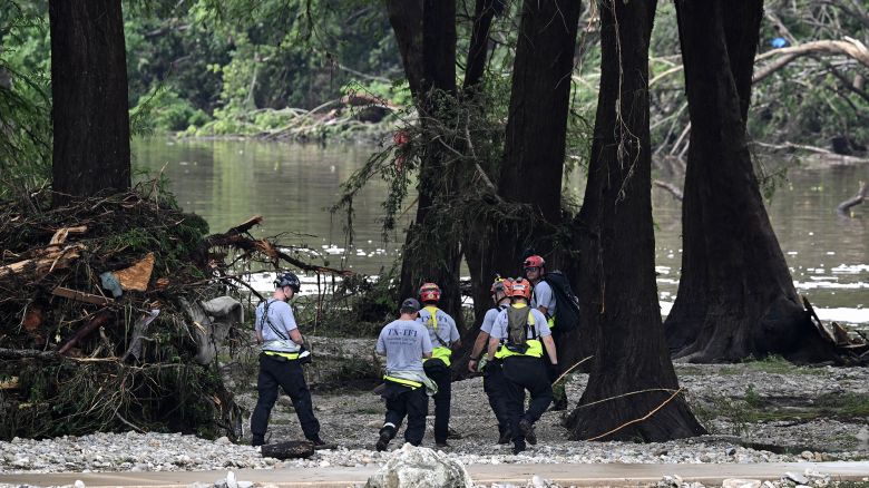 Members of a search and rescue team look for people near Camp Mystic, the site of where at least 20 girls went missing after flash flooding in Hunt, Texas, on July 5, 2025. Rescuers were on Saturday searching for more than 20 girls missing from a riverside summer camp in the US state of Texas, after torrential rains caused devastating flooding that killed at least 27 people -- with more rain on the way. "So far, we've evacuated over 850 uninjured people, eight injured people and have recovered 27 deceased fatalities at this time. Of these 27, 18 are adults, nine are children," said Kerr Country Sheriff Larry Leitha on July 5. (Photo by RONALDO SCHEMIDT / AFP) (Photo by RONALDO SCHEMIDT/AFP via Getty Images)          