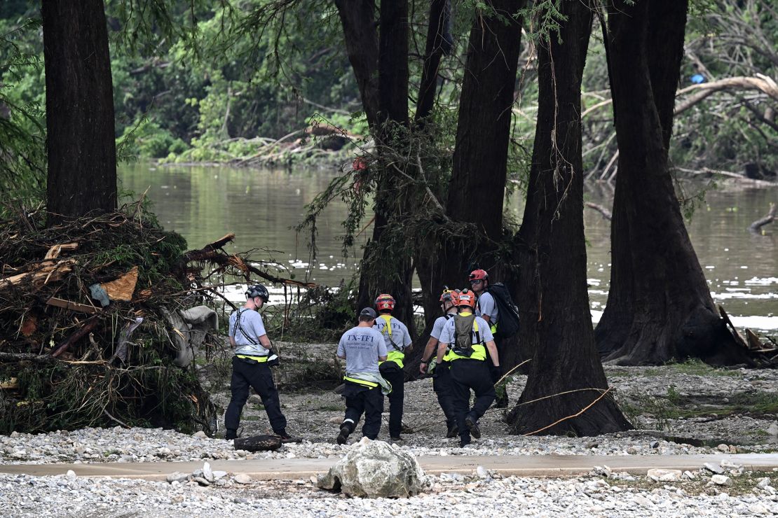 Members of a search and rescue team look for people near Camp Mystic in Hunt, Texas, on Saturday.