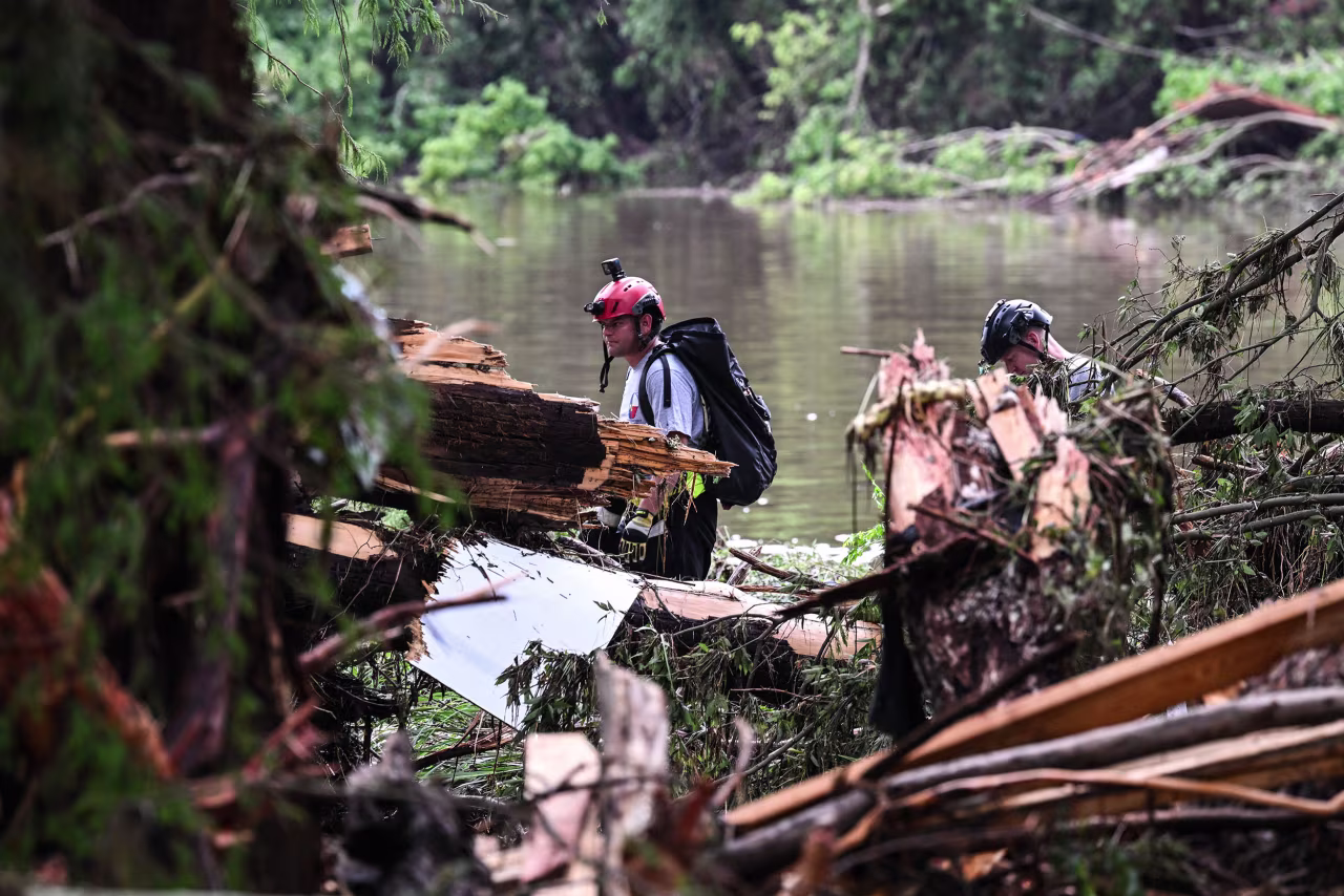 Members of a search and rescue team look for people near Camp Mystic in Hunt, Texas, on Saturday.