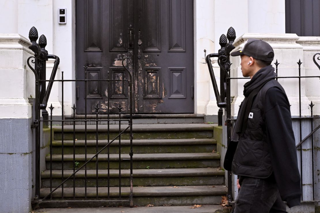 A man walks past the burnt front entrance of the East Melbourne Synagogue in Melbourne on July 6, 2025.