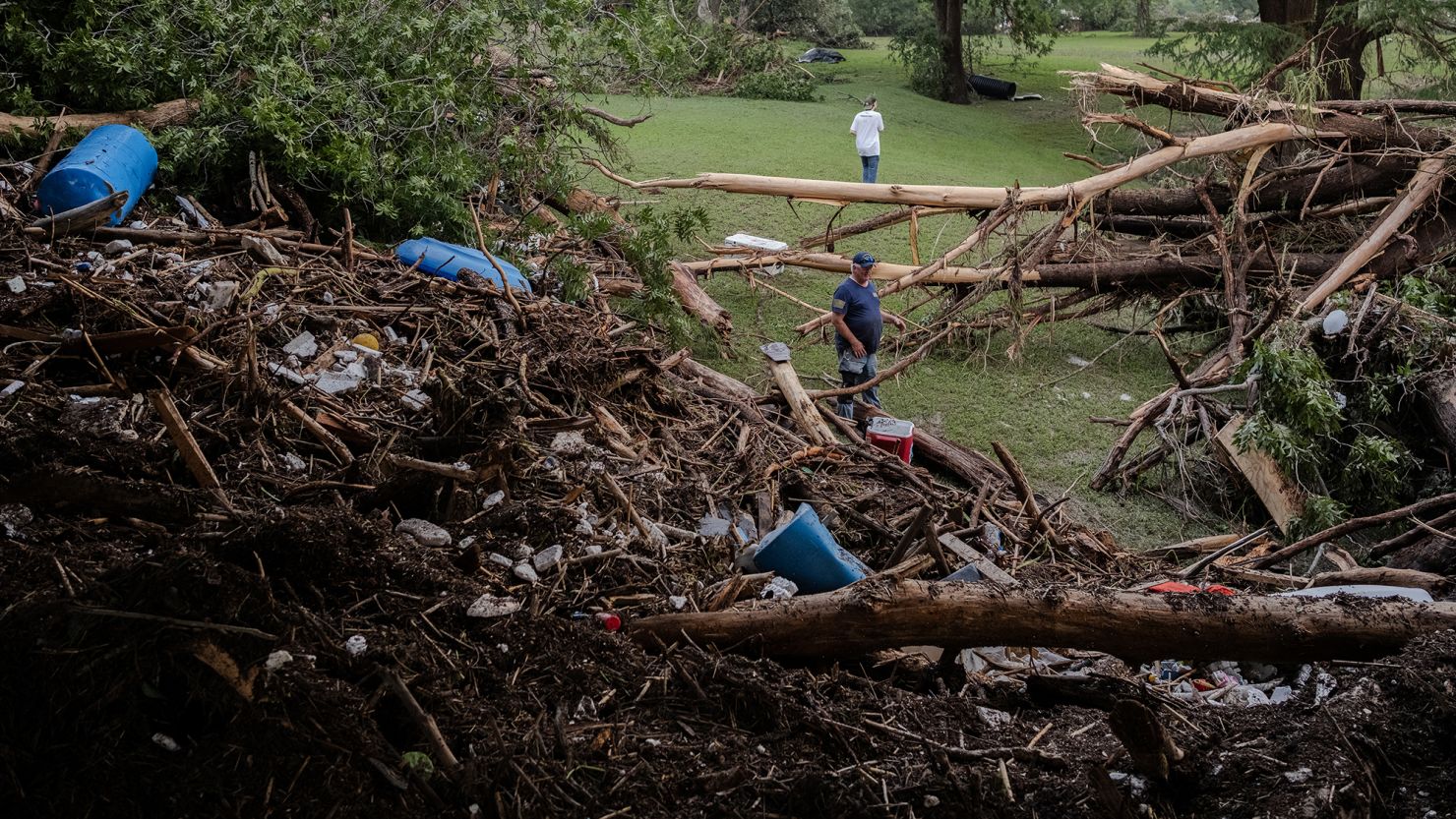 Two men search for survivors after flash flooding on the bank of the Guadalupe River in Center Point, Texas.