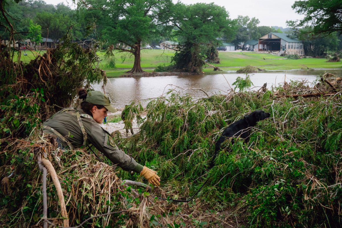 A K-9 unit searches along the Guadalupe River near Camp Mystic on Saturday.