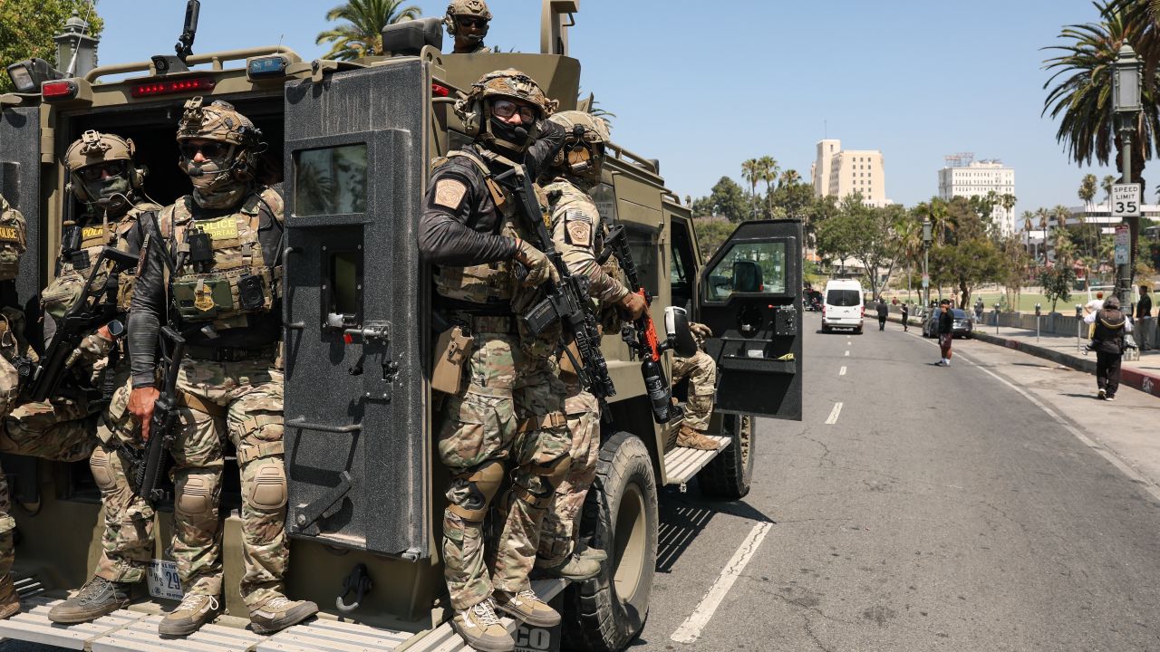 Federal agents with US Customs and Border Patrol (CBP) ride on an armored vehicle driving slowly down Wilshire Boulevard near MacArthur Park in Los Angeles, California, on July 7, 2025. (Photo by Patrick T. Fallon / AFP) (Photo by PATRICK T. FALLON/AFP via Getty Images)