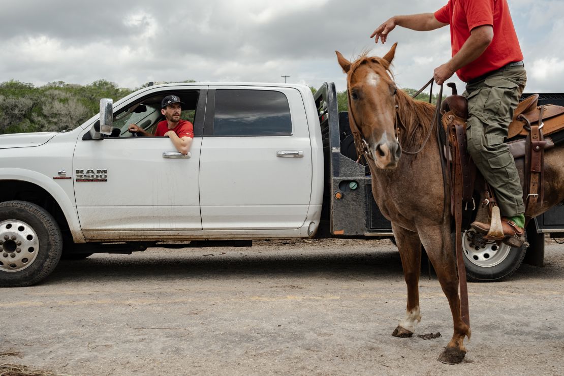 Search and rescue workers speak to one another near Camp Mystic as they look for any survivors or remains of people swept up in the flash flooding in Hunt, Texas.