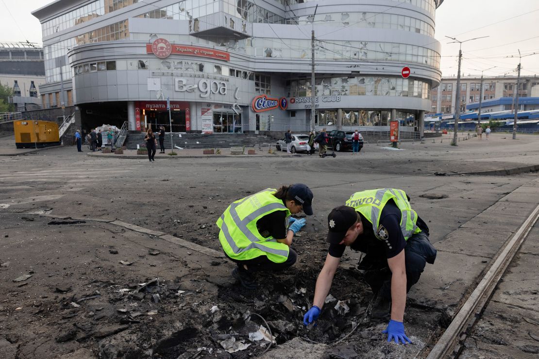 Police officers examine debris on a street after a night of Russian strikes in Kyiv on July 10.