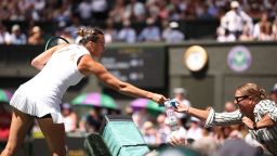Belarus's Aryna Sabalenka gives water to a member of the public in distress due to the heat and the sun during herwomen's singles semi-final tennis match against US player Amanda Anisimova on the eleventh day of the 2025 Wimbledon Championships at The All England Lawn Tennis and Croquet Club in Wimbledon, southwest London, on July 10, 2025. (Photo by HENRY NICHOLLS / AFP) / RESTRICTED TO EDITORIAL USE (Photo by HENRY NICHOLLS/AFP via Getty Images)          
