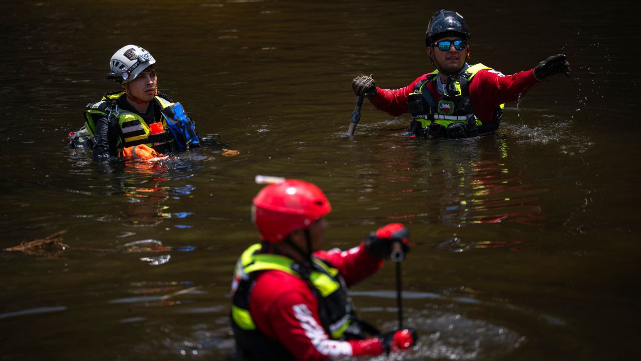Members of a firefighter crew from Mexico assist in recovery efforts by searching for bodies in the Guadalupe River outside of Camp Mystic in Hunt, Texas, US, on Thursday, July 10, 2025. Crews in central Texas are digging through massive piles of debris, overturned vehicles and shattered homes as the search continues for victims of flash floods that killed more than 100 people over the Fourth of July weekend. Photographer: Eli Hartman/Bloomberg via Getty Images