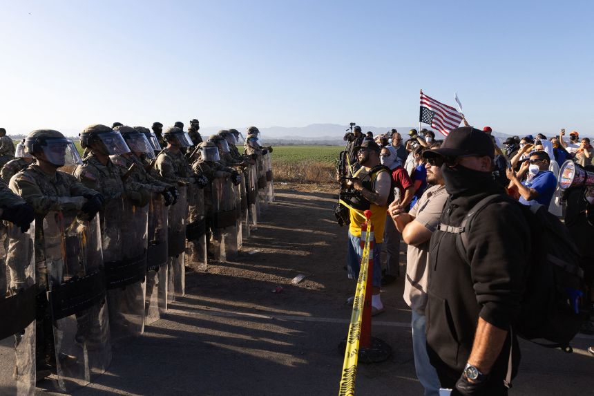 California National Guard troops face off with protestors during a raid on Glass House Farms in Camarillo, California, on Thursday.