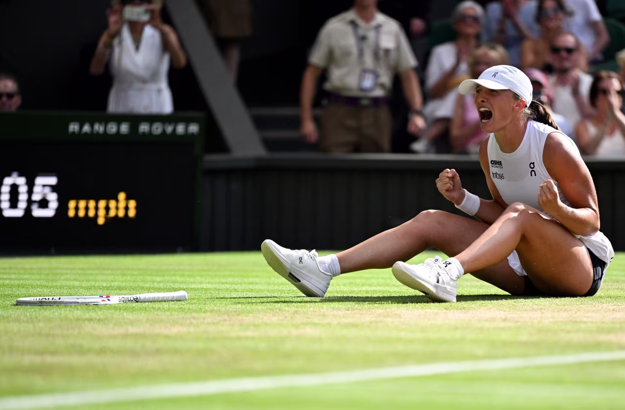 Iga Świątek celebrates after winning her first Wimbledon title.
