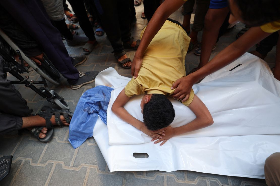 A boy leans over the body of his cousin after he was killed in an Israeli strike that hit Nuseirat in central Gaza on July 13.