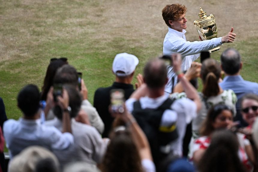 Sinner, the first Italian to win the title, celebrates with the Wimbledon trophy.