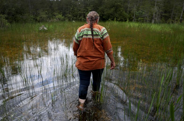 Betty Osceola, a member of the Miccosukee Tribe of Indians of Florida, walks in the Everglades a few yards from the front entrance to "Alligator Alcatraz" at the Dade-Collier Training and Transition Airport on July 10, 2025 in Ochopee, Florida.