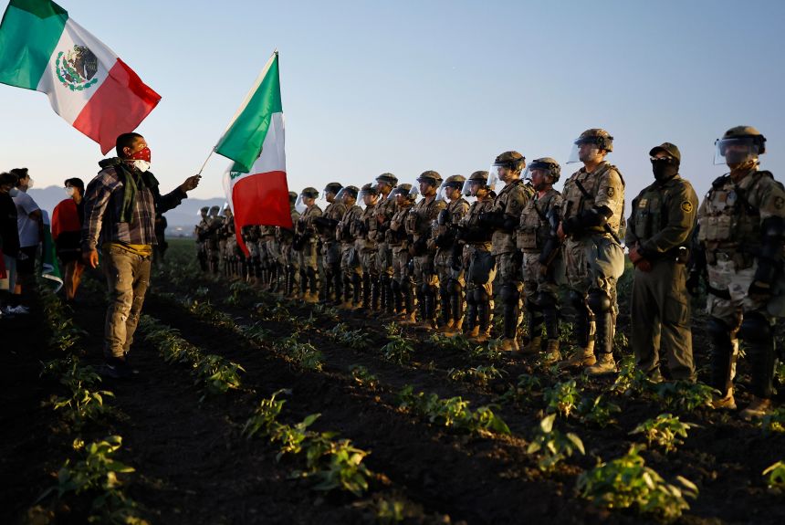 National Guard members and a federal agent block people protesting an ICE immigration raid at a nearby licensed cannabis farm near Camarillo, California, on July 10.