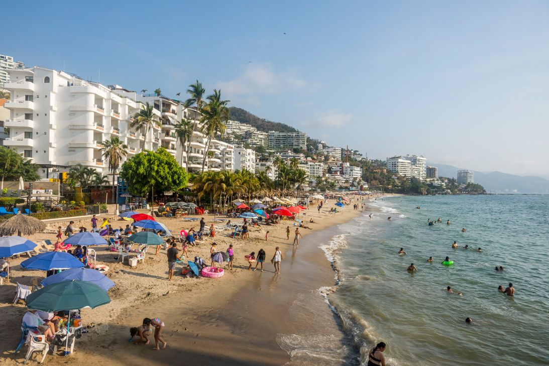 Beachgoers enjoy Playa de Los Muertos in Puerto Vallarta, Mexico. This lively area is popularly known as the Zona Romántica (Romantic Zone).