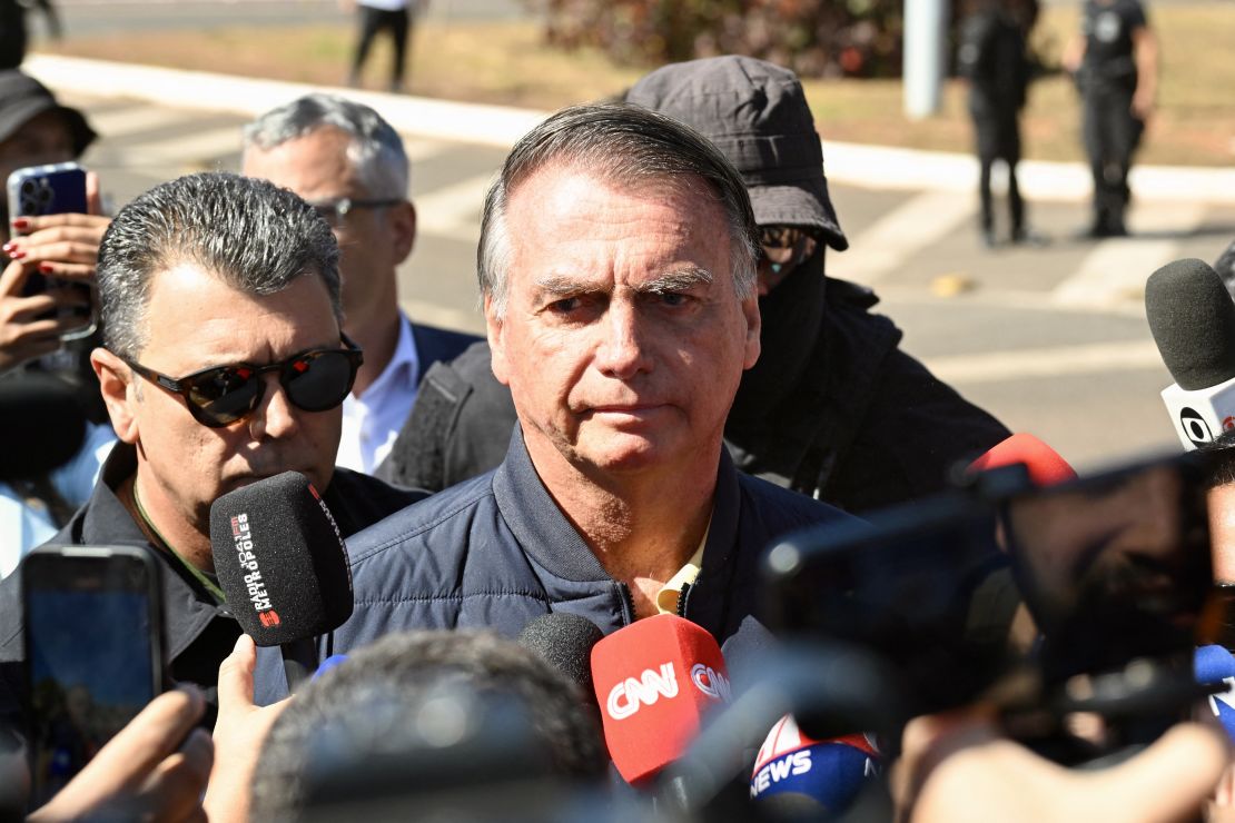 El expresidente brasileño Jair Bolsonaro observa mientras habla con la prensa tras serle implantado un dispositivo de monitoreo electrónico en Brasilia el 18 de julio de 2025.