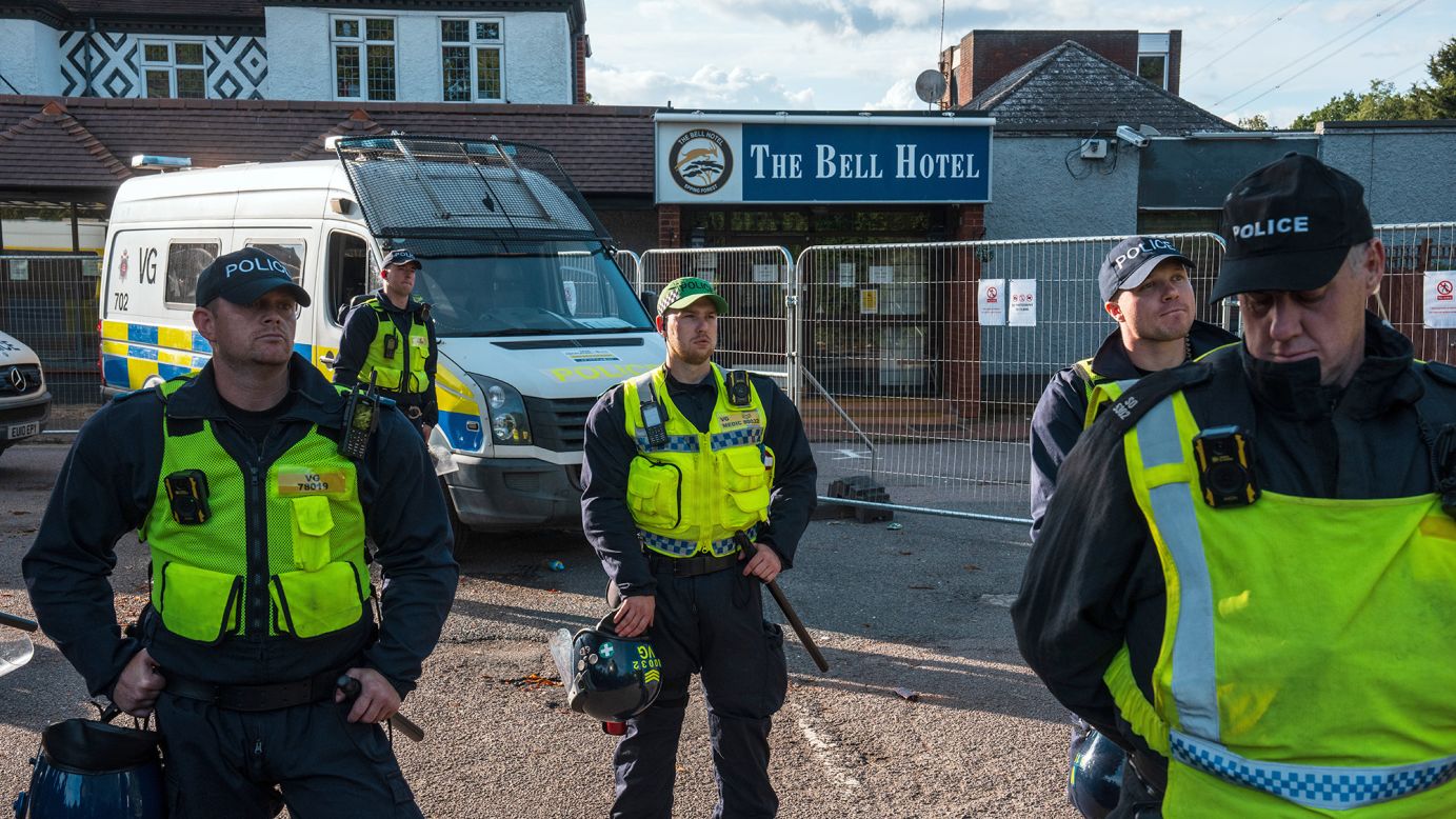 Police officers guard the Bell Hotel in Epping from anti-immigration protesters.