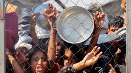 TOPSHOT - Palestinians, mostly children, push to receive a hot meal at a charity kitchen in the Mawasi area of Khan Yunis in the southern Gaza Strip on July 22, 2025. The head of Gaza's largest hospital said 21 children have died due to malnutrition and starvation in the Palestinian territory in the past three days, amid a devastating assault by Israeli forces. (Photo by AFP) (Photo by -/AFP via Getty Images)          