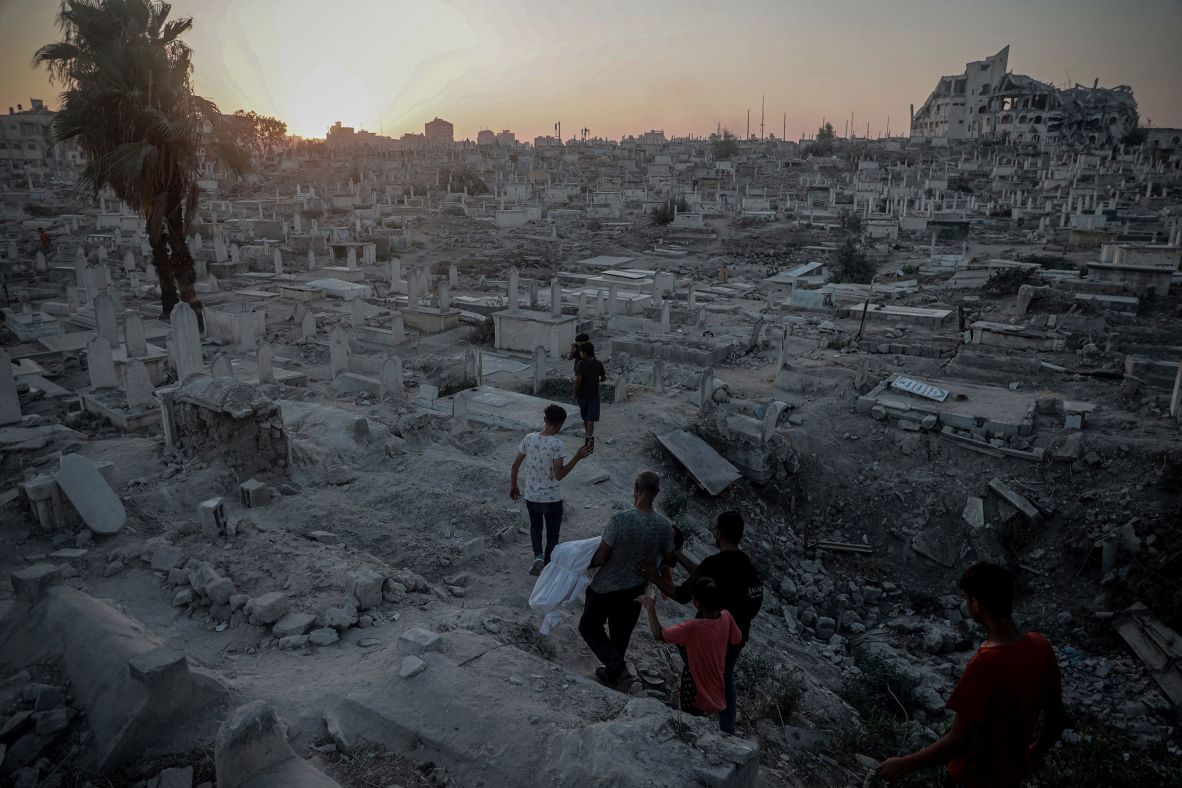 People carry a child’s body into a Gaza City cemetery for burial on Tuesday, July 22. The child lost their life in an Israeli strike.