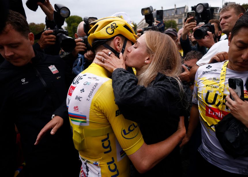 Tadej Pogačar celebrates winning the Tour de France with his partner.
