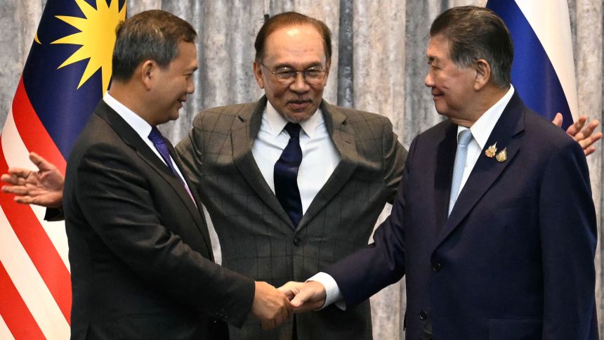 Cambodia's Prime Minister Hun Manet (L) and Thailand's acting Prime Minister Phumtham Wechayachai (R) shake hands as Malaysia's Prime Minister Anwar Ibrahim (C) puts his arms around them after announcing the ceasefire on Monday.