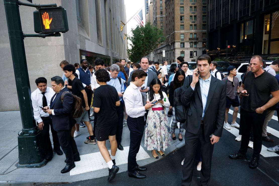 Personas se reúnen cerca de una acera mientras la Policía responde a un tiroteo ocurrido en las cercanías en Nueva York el lunes.