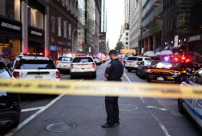 An officer stands in a street as police respond to a shooting in Midtown Manhattan on July 28.