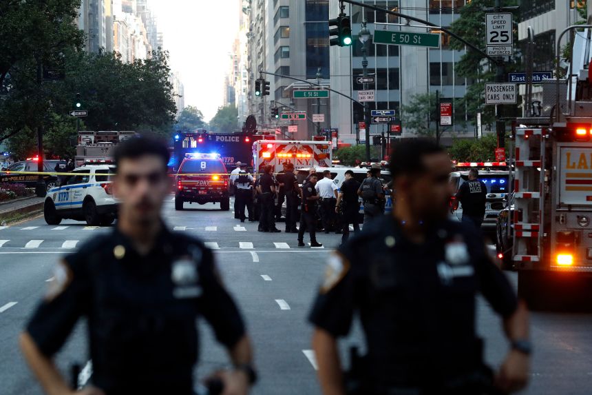 Police officers and emergency vehicles respond to a shooting in Midtown Manhattan on July 28.