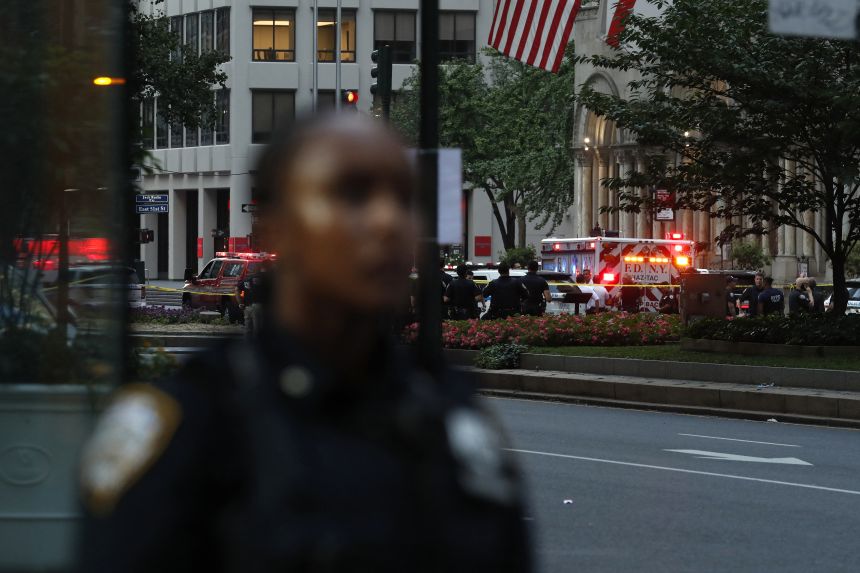 Police officers and emergency vehicles are seen in a street as police respond to a shooting incident in the Midtown Manhattan neighborhood of New York on July 28.