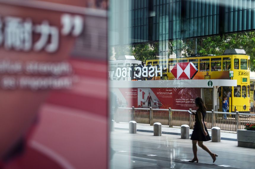 The HSBC Holdings Plc logo atop a tram station outside the bank's headquarters building in Hong Kong.