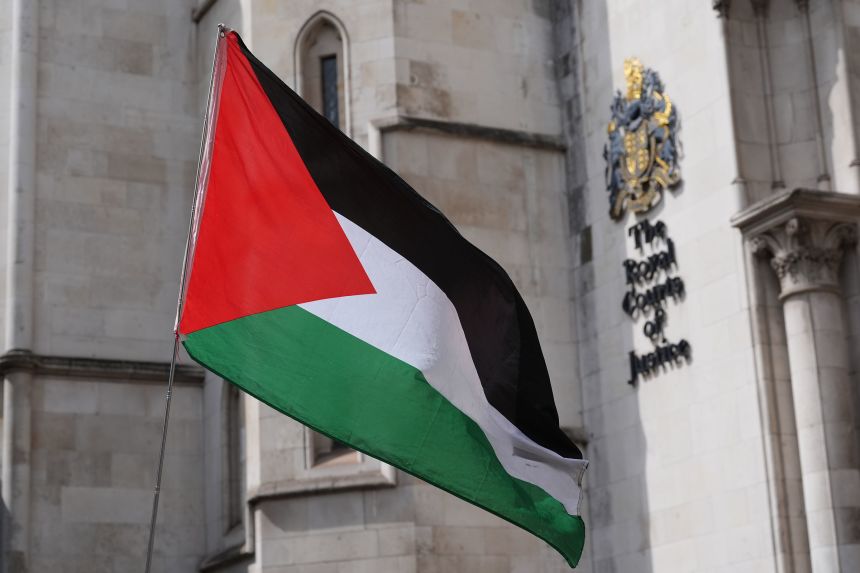 A Palestinian flag is waved outside The Royal Courts of Justice in central London on Wednesday.