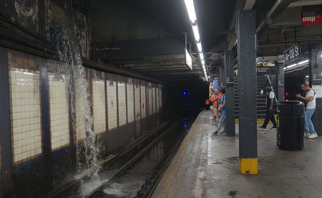 Water from torrential rainfall pours onto the tracks at a subway station in New York on July 31.