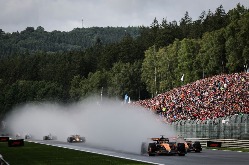 Piastri overtakes Lando Norris as spray flies up into the drivers' faces.