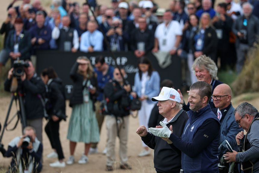 President Donald Trump stands next to Eric Trump as he opens his new golf course at his Trump International Golf links resort in Balmedie, Scotland, on July 29, 2025.