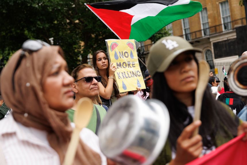 Pro-Palestinian demonstrators hold placards and flags in front of Downing Street on Tuesday, as the prime minister convened an emergency cabinet meeting to discuss his government's policies on Gaza.
