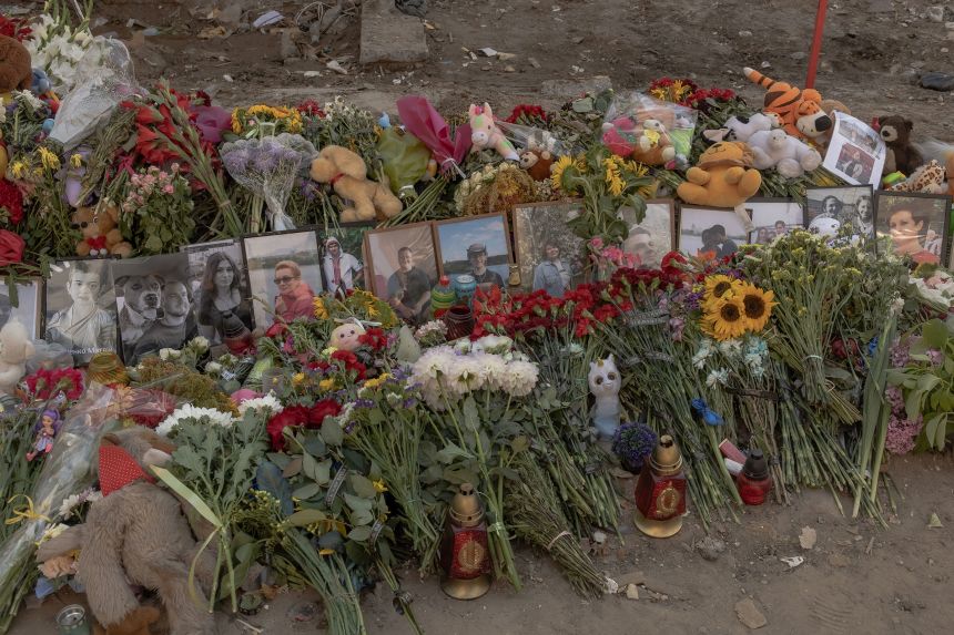 Flowers, children's toys and victims' portraits form a makeshift memorial at the site of a residential building destroyed by a Russian missile strike in Kyiv, pictured on August 5.