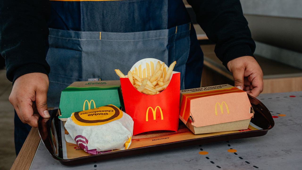 An employee carries a tray of food, including french fries and hamburgers, to a customer at a McDonald's restaurant in Zion, Illinois, on February 19, 2025.