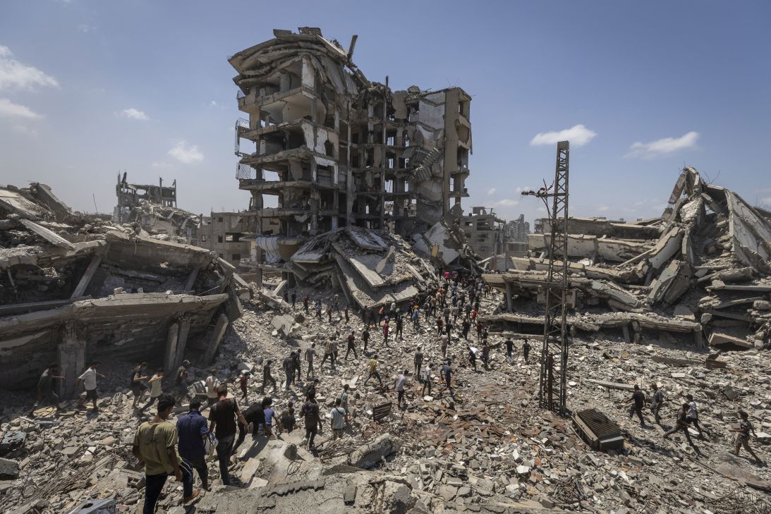 Palestinians flock to the area where planes dropped aid packages in western Gaza City on August 7, 2025.