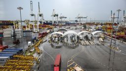 Trucks carrying shipping containers are seen at the Port of Miami in Miami, Florida, on August 7, 2025.