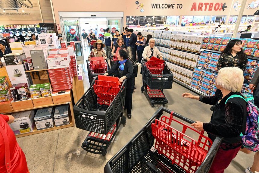 Los clientes ingresarán a una tienda de comestibles en Westminster, California, el 7 de agosto.