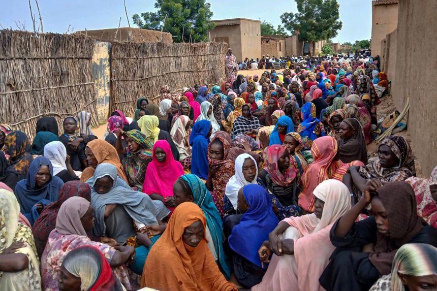 Sudanese residents gather to receive free meals in El Fasher, a city besieged by Sudan's paramilitary Rapid Support Forces (RSF) for more than a year, in Darfur region, on August 11, 2025.