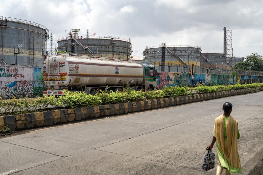 An oil tanker passes storage tanks at an oil refinery in Mumbai, India, on August 11. Washington is ratcheting up the pressure on New Delhi over oil flows from Russia with a wave of new tariffs.