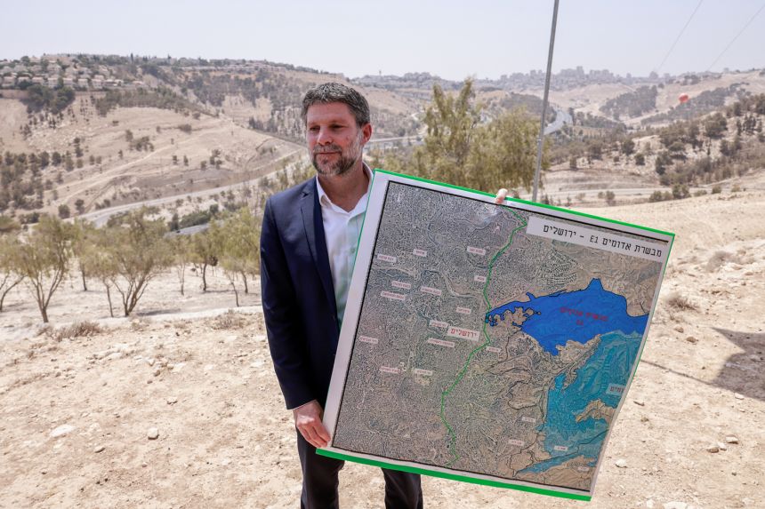 Israeli far-right Finance Minister Bezalel Smotrich holds a map of an area near the settlement of Maale Adumim in the occupied West Bank on August 14.
